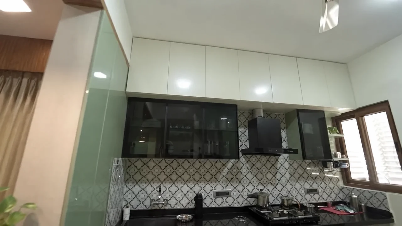 Kitchen cabinetry with a patterned backsplash and cooking counter