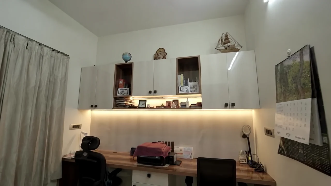 A study desk with overhead cabinets and task lighting